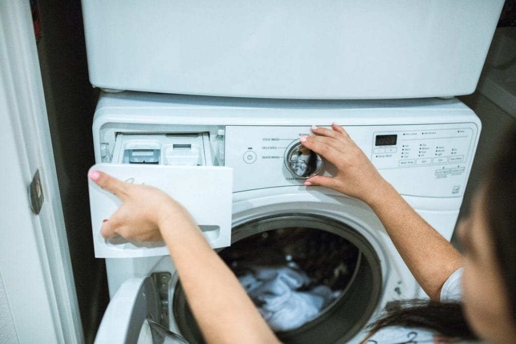 Person holding white front load washing machine