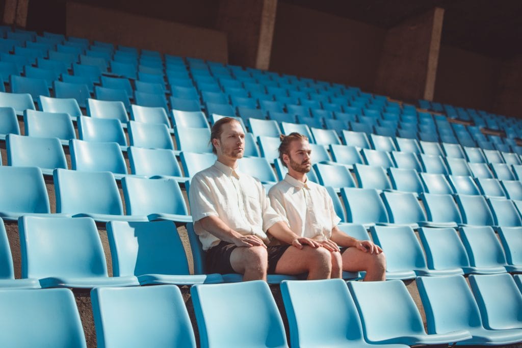 Serious men sitting on chair on stadium